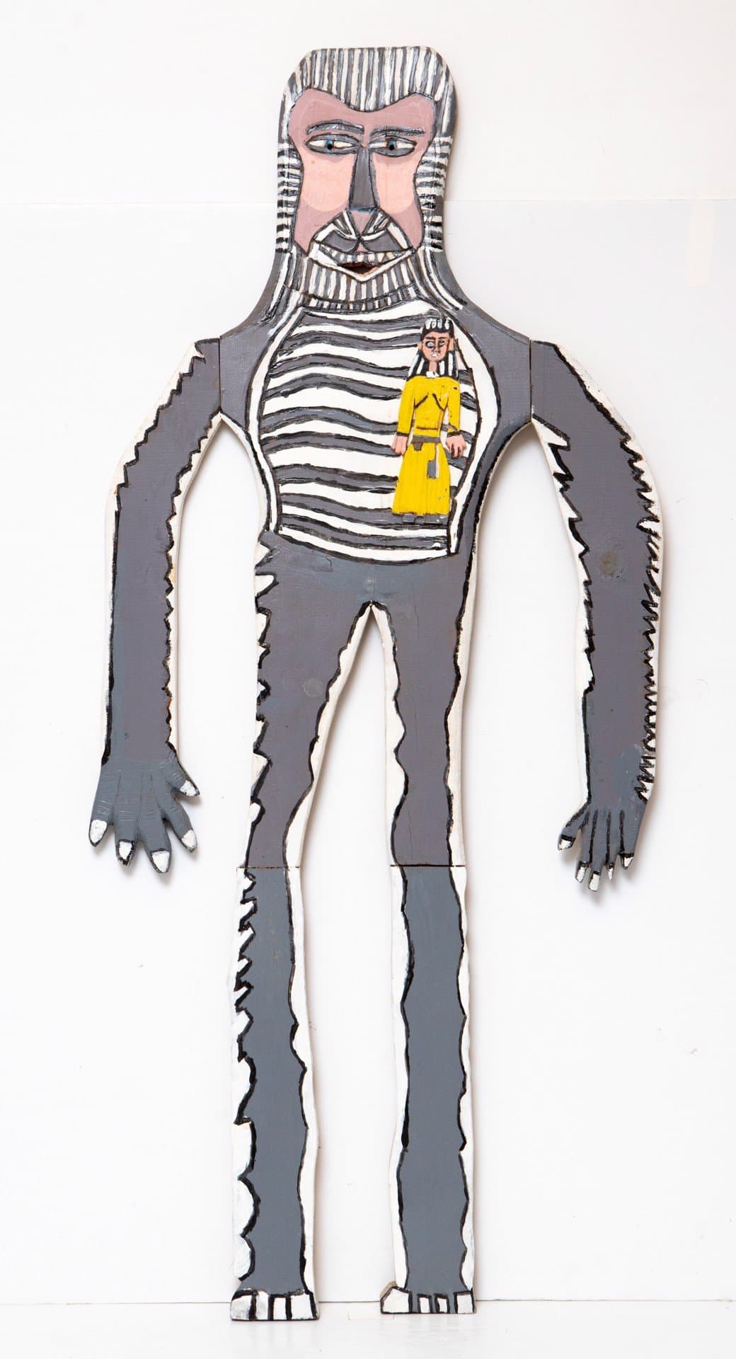 Cut-out wooden figure painted with acrylic depicting a bearded man in gray clothing with striped chest panel.