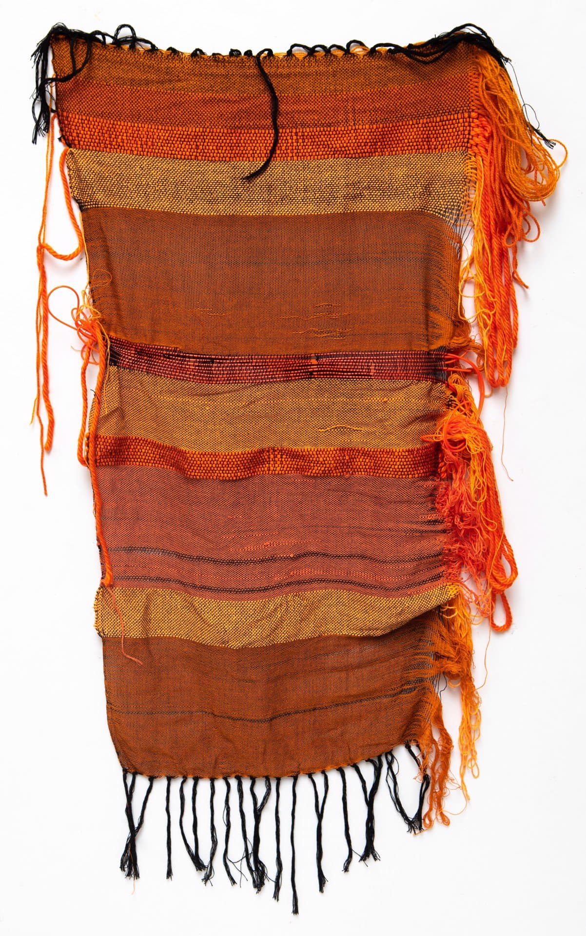 Woven textile with horizontal bands in orange, brown, and gold tones with fringe edges and loose threads